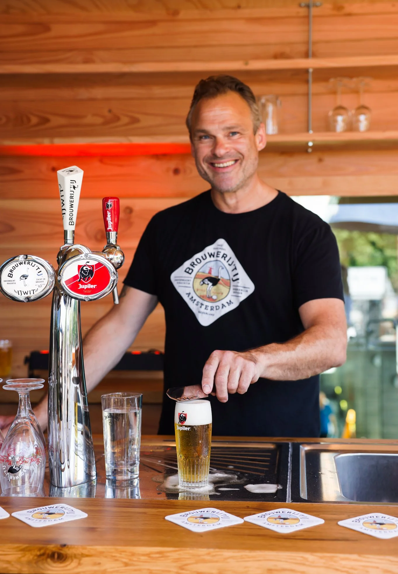 Medewerker tapt een biertje achter de bar van Het Plantsoen